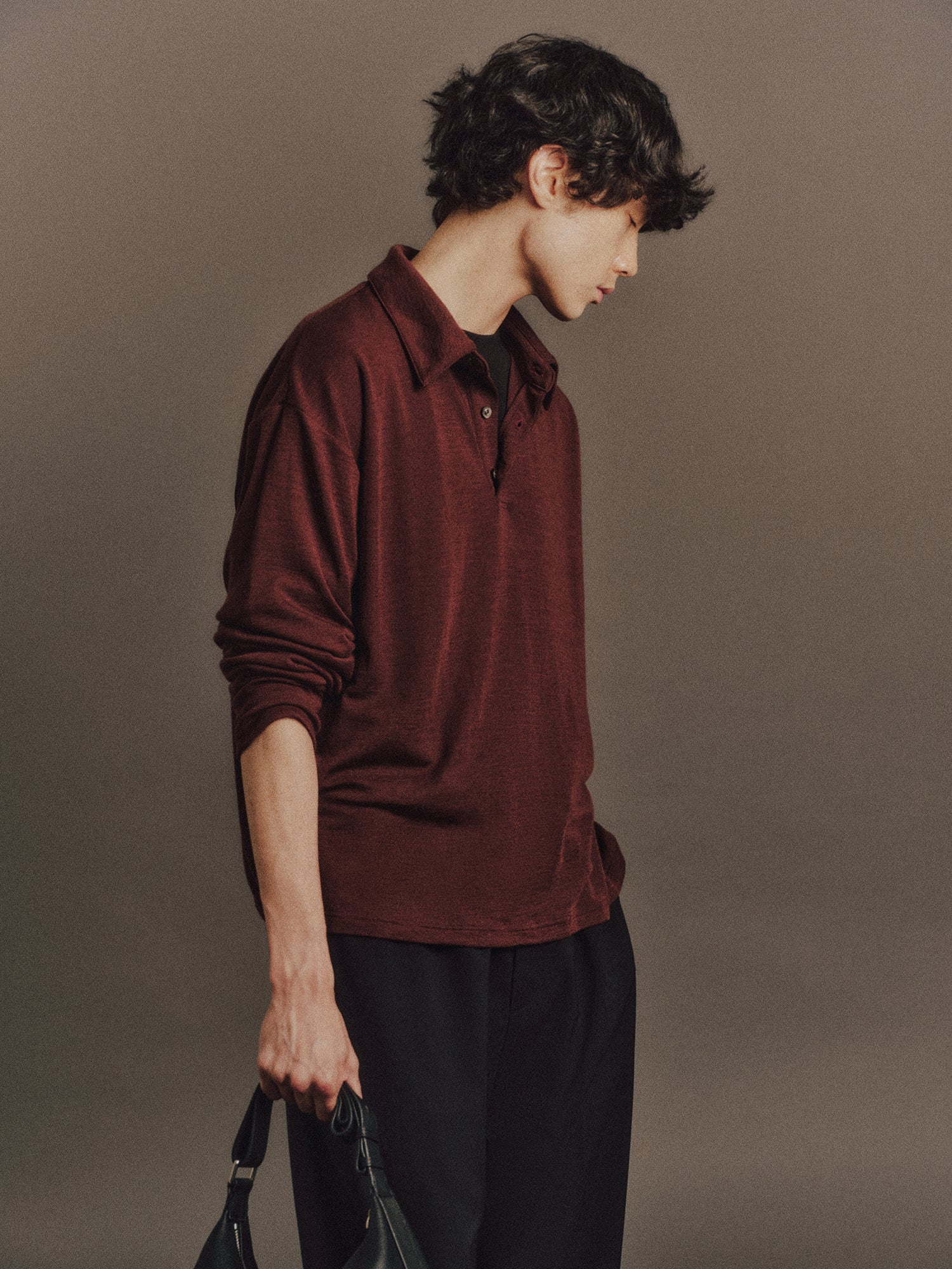 Émile wears Aurora Top In Burgundy, Carlos Pant in Black, Cow Leather Aura Bag In Black