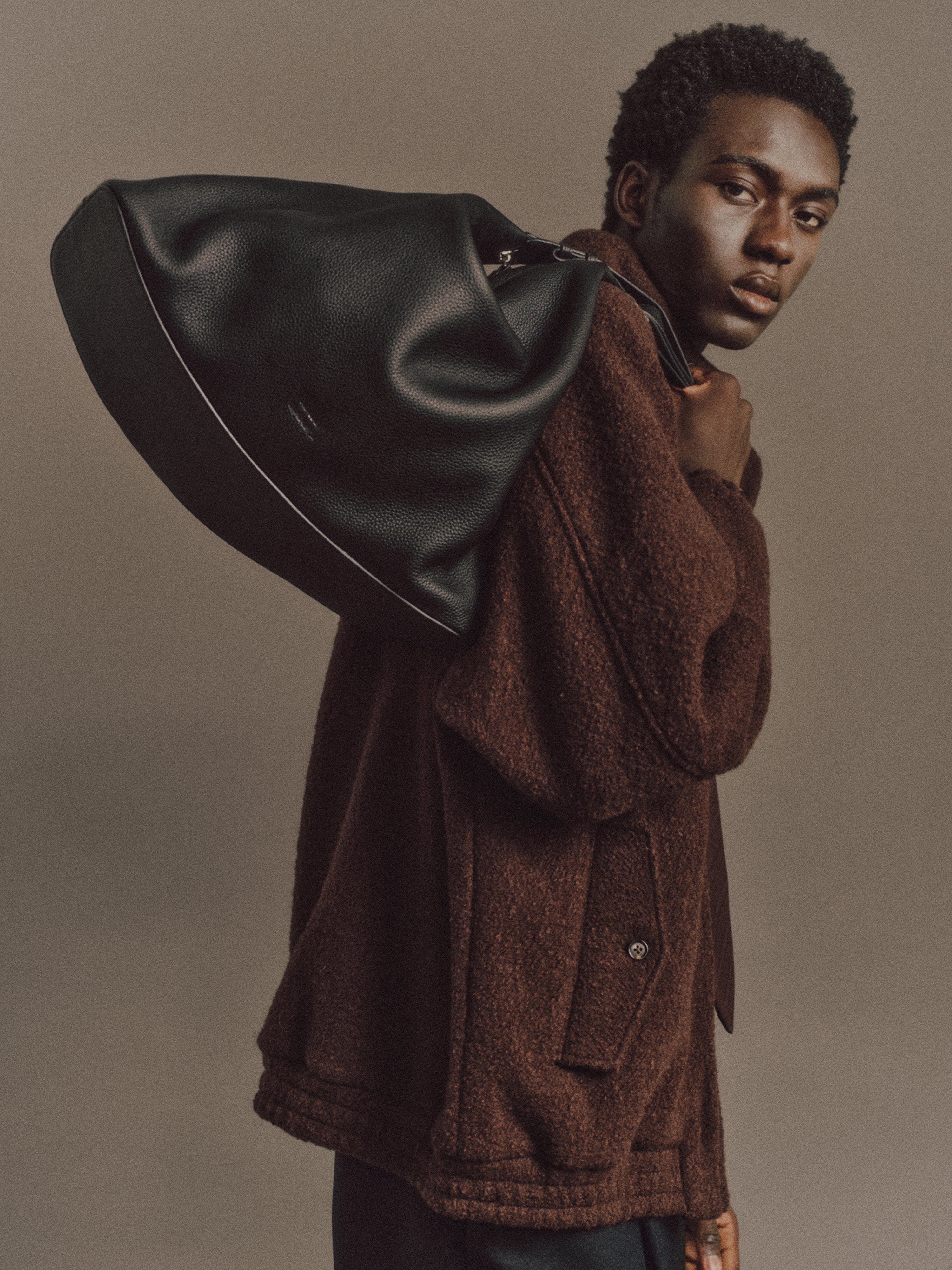 Muhamed wears Haley Shirt in Light Blue, Luka Pant in Black, Charlotte Tie In Wine Red Stripe, Shell Belt In Vintage Silver, Cow Leather Aura Bag In Black