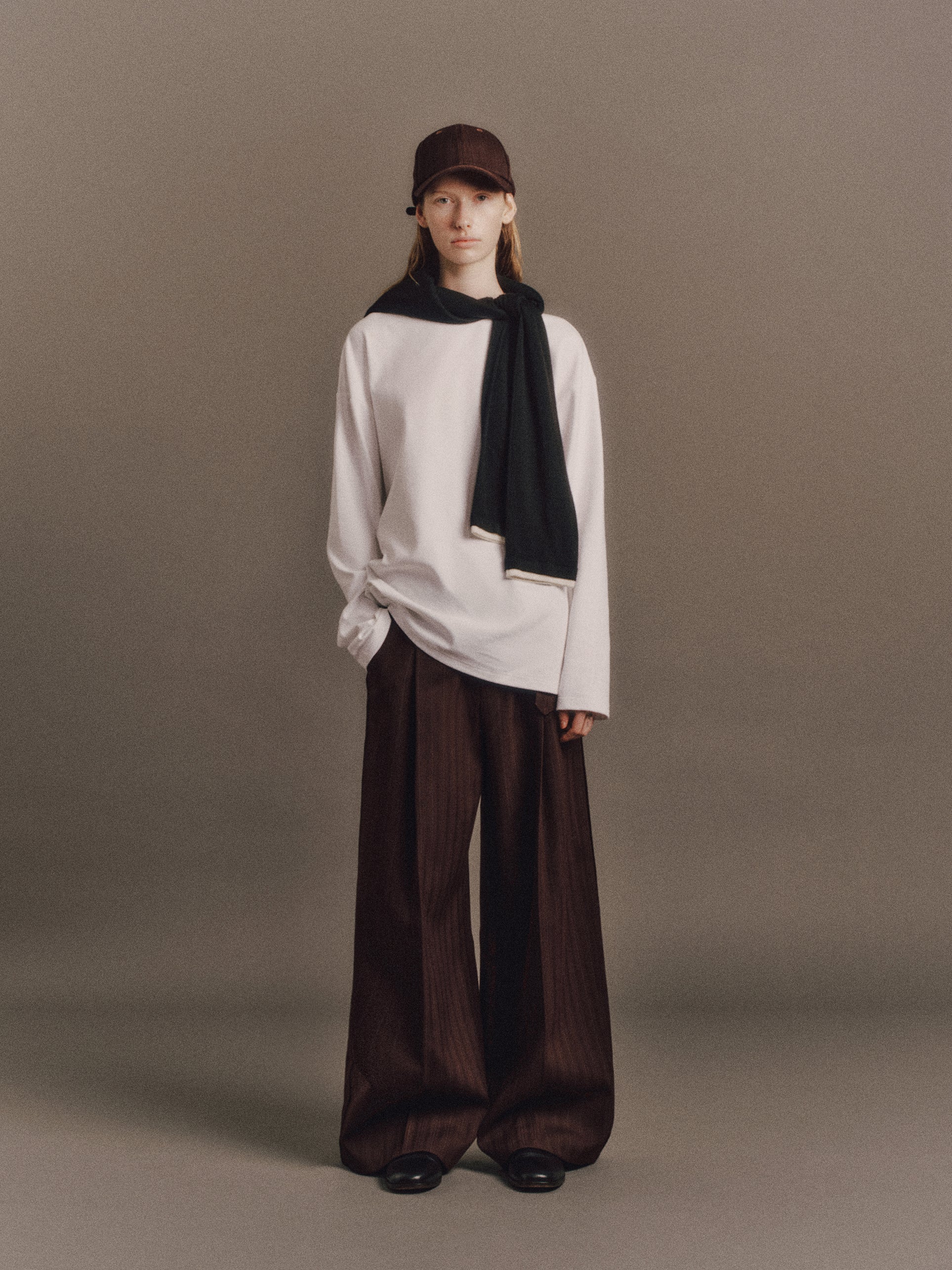 Tyla wears Denzel Top In White, Austin Sweater In Black, Cody Pant In Wine Red Stripe