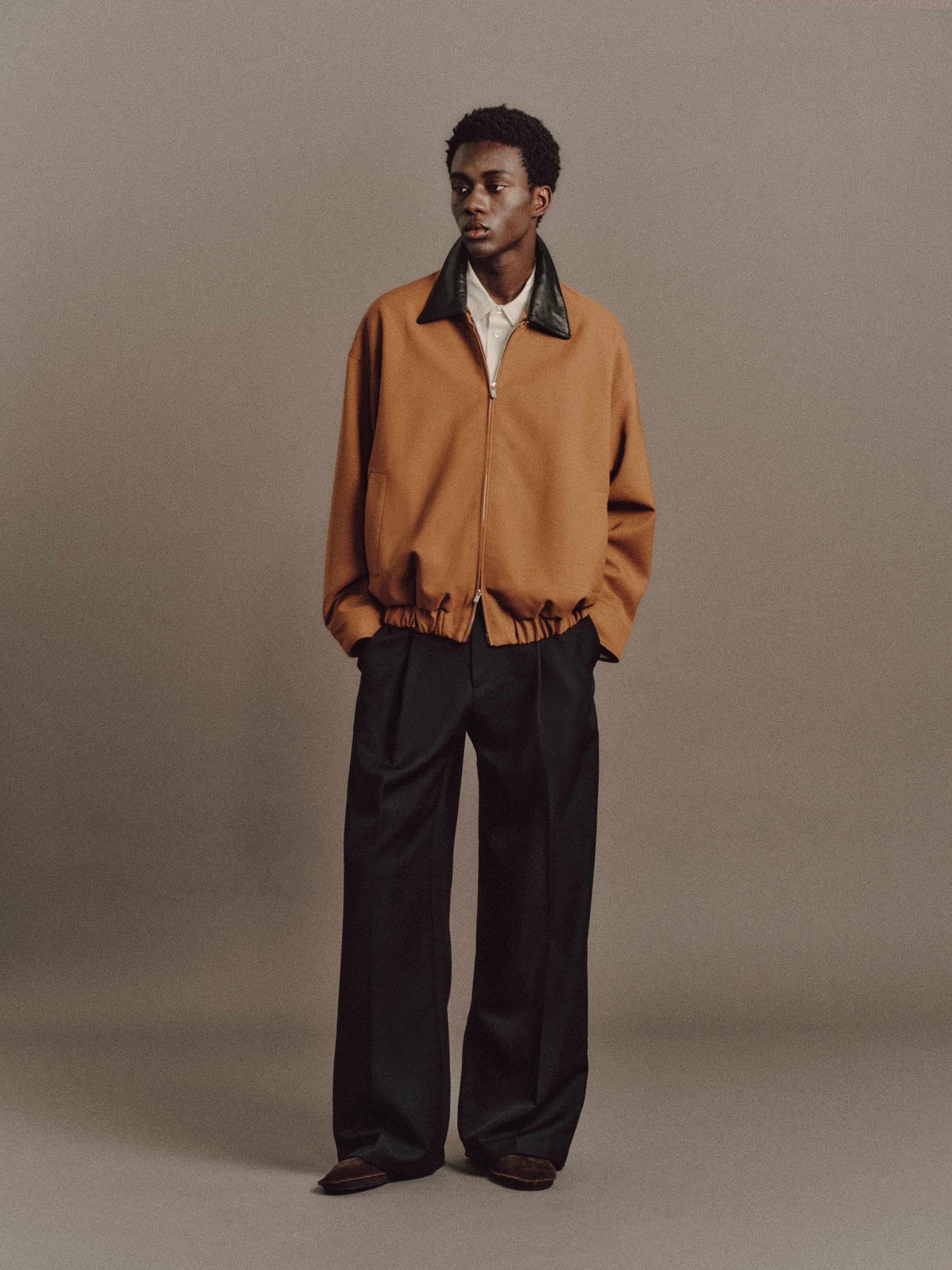 Muhamed wears Burt Shirt In Light Green, Krauter Jacket In Brown, Luka Pant In Black