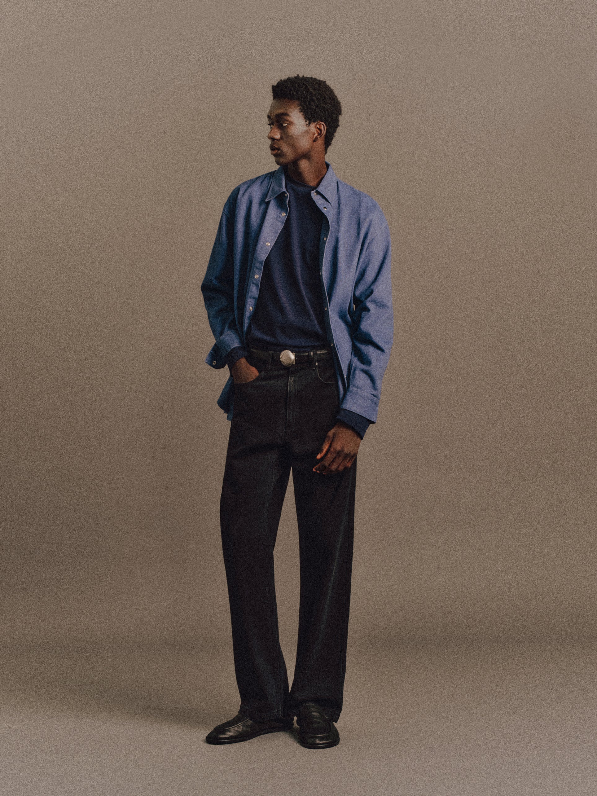 Muhamed wears Drago Shirt In Blue Violet, Denzel Top In Navy, Leo Jean In Washed Black, Shell Belt In Vintage Silver